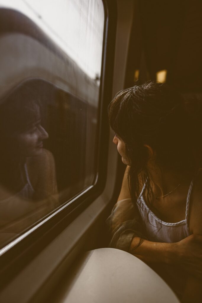 a woman sitting on a train looking out the window